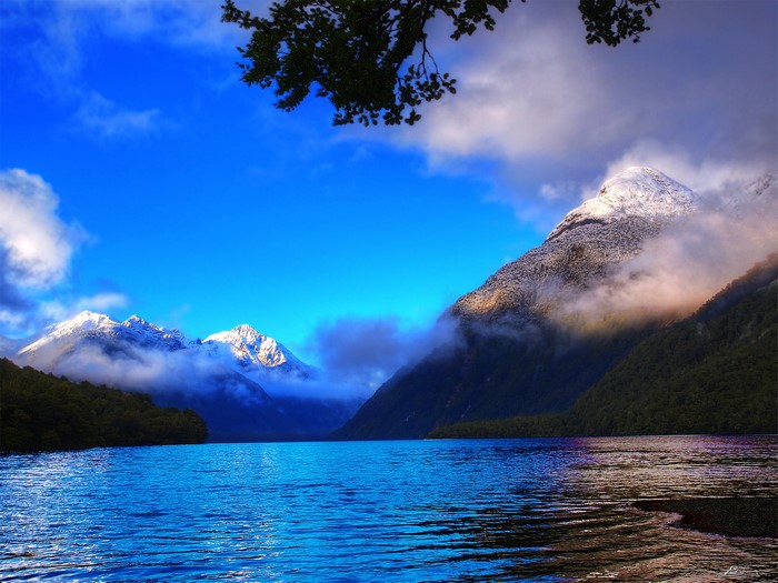 Snow-capped mountains reflected in a lake in New Zealand