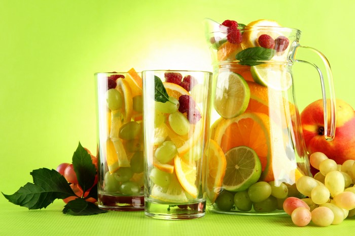 Fruit-filled pitcher and glasses with grapes and peach