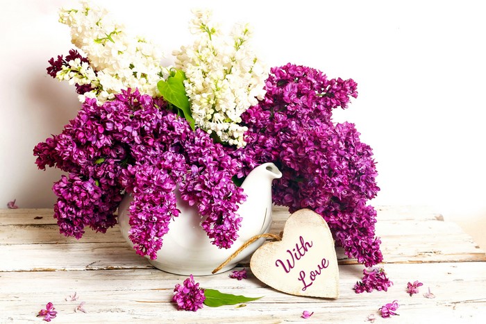 Lilac flowers in a vase with a heart decoration