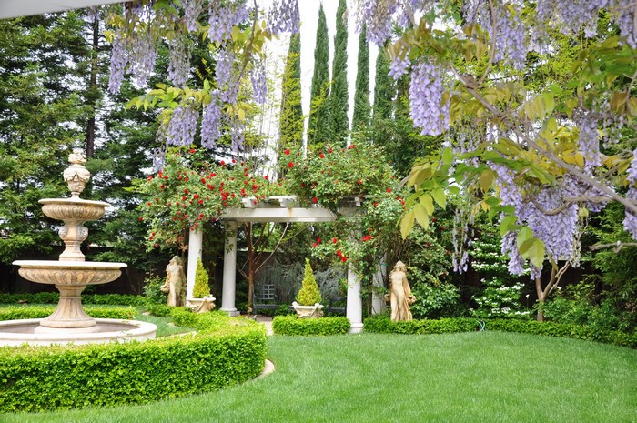 Garden with fountain, pergola, roses, and wisteria