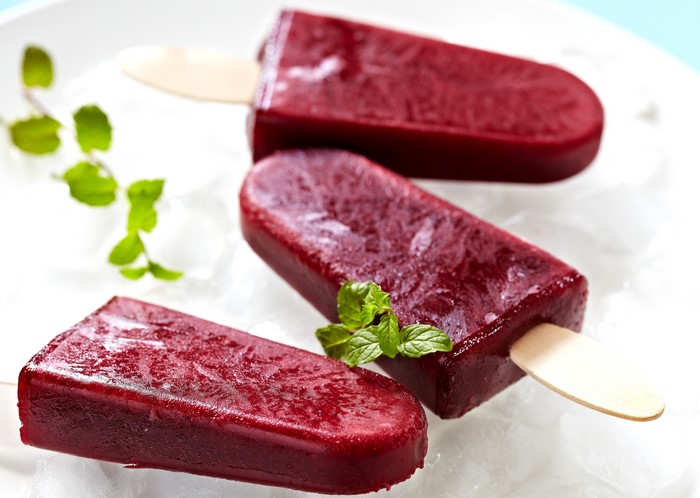 Three berry popsicles on ice
