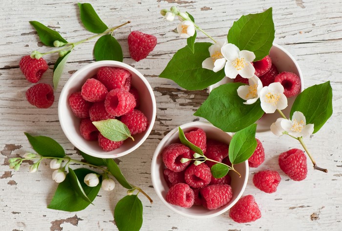 Raspberries in bowls with jasmine flowers