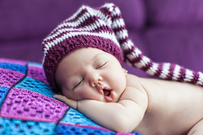 Baby sleeping in a striped hat