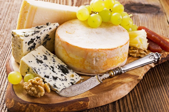 Cheese board with grapes, nuts, and knife
