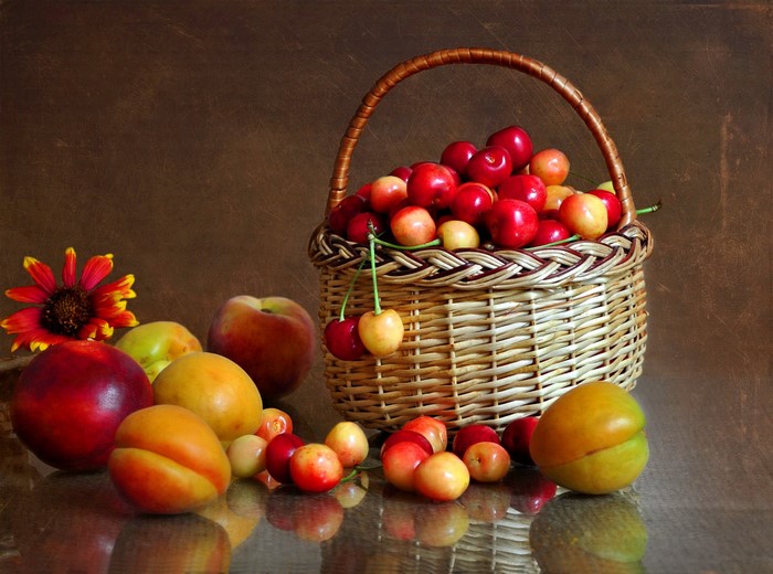 Still life of fruit in a basket with a flower