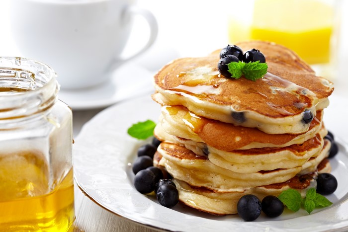 Pancakes with blueberries, honey, and coffee