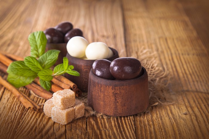 Sweets and candies on a wooden table with cinnamon and mint