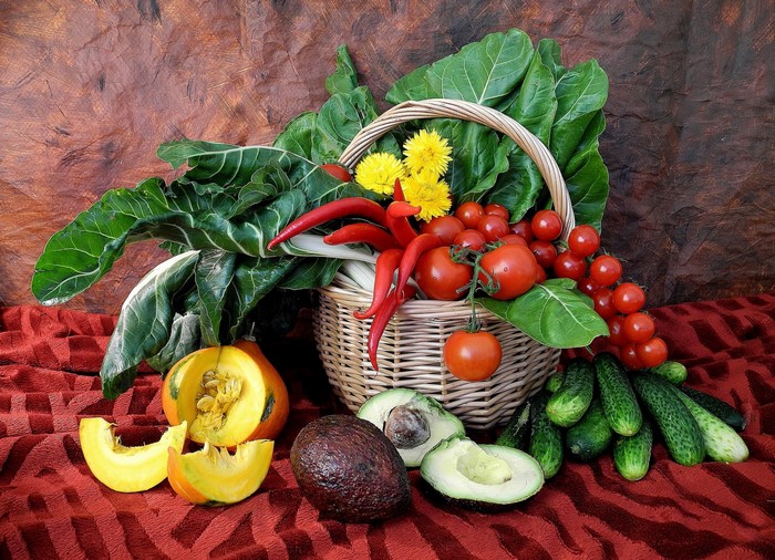 Vegetable still life with basket, pumpkin, and avocado