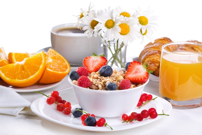 Breakfast with cereal, fruit, croissants, coffee, and orange juice