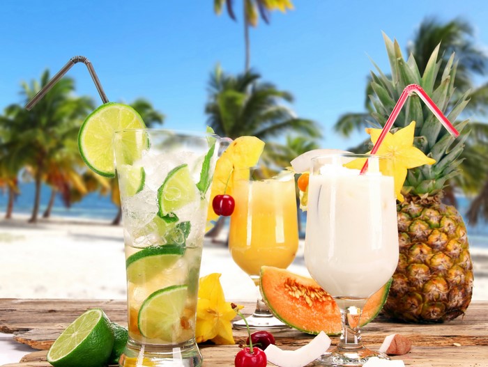 Tropical Drinks with Fruits on a Beach Background