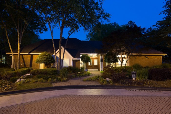 Building entrance at dusk with trees and shrubs