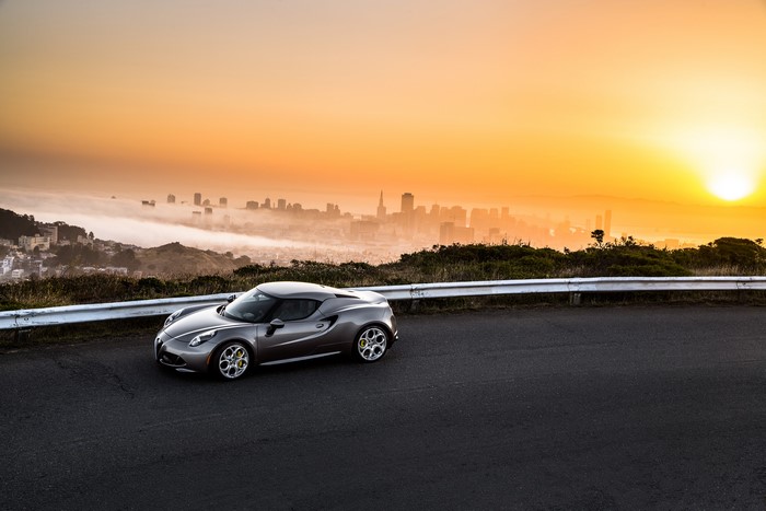 Alfa Romeo 4C parked on a road overlooking San Francisco at sunrise
