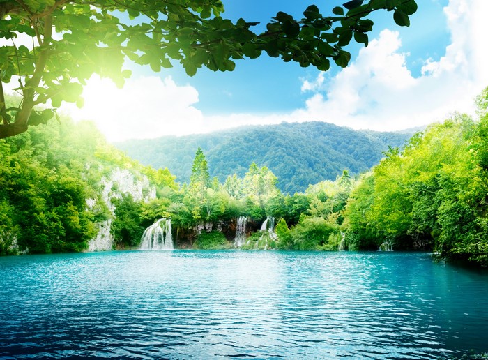 Turquoise lake with waterfalls and lush green mountains