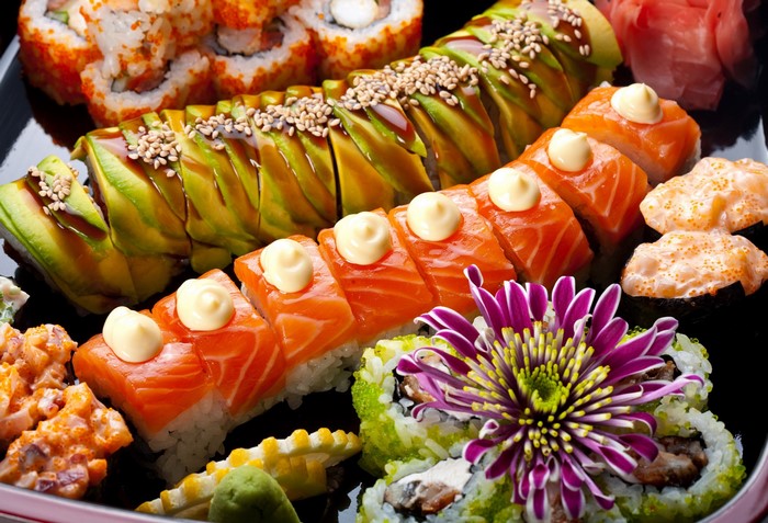 Assortment of sushi and sashimi on a black plate