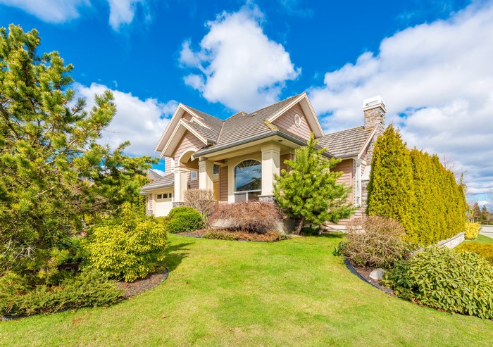 Luxury house with manicured lawn and trees