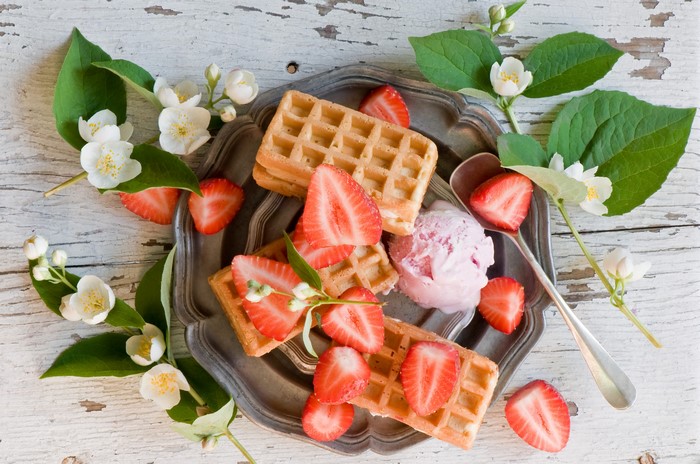 Waffles with strawberries and ice cream, decorated with jasmine