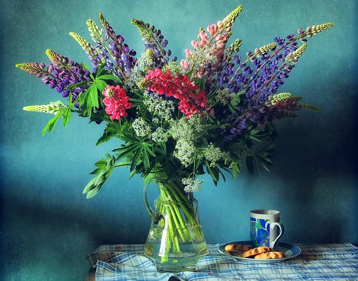 Still-life with Lupinus flowers in a vase and a cup of tea