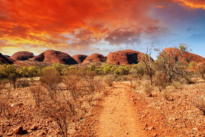 Desert landscape with rock formations and red sky