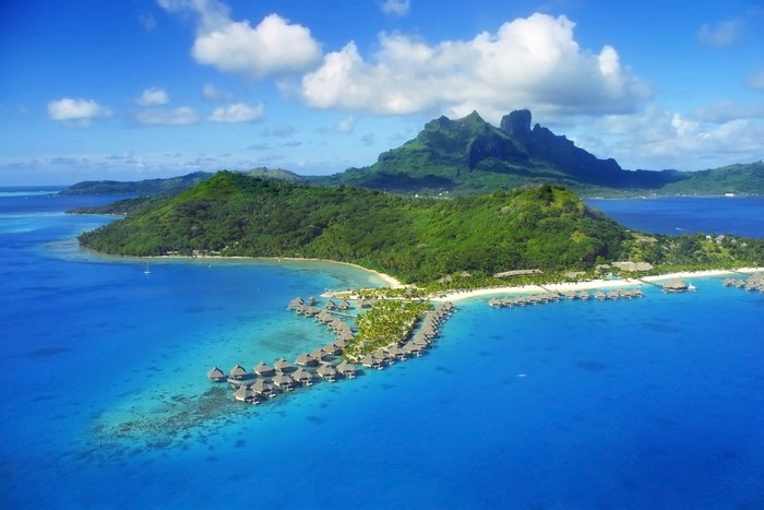 Aerial view of Bora Bora with overwater bungalows and mountains
