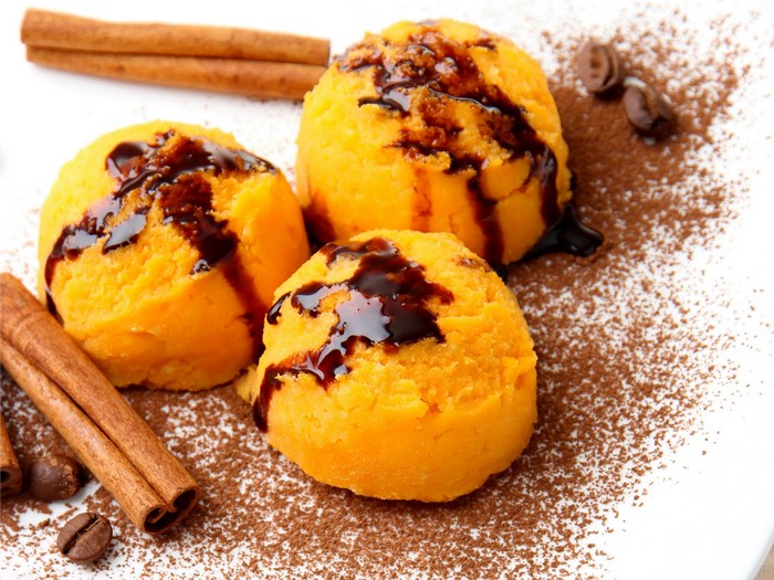 Orange ice cream scoops with chocolate syrup and cinnamon