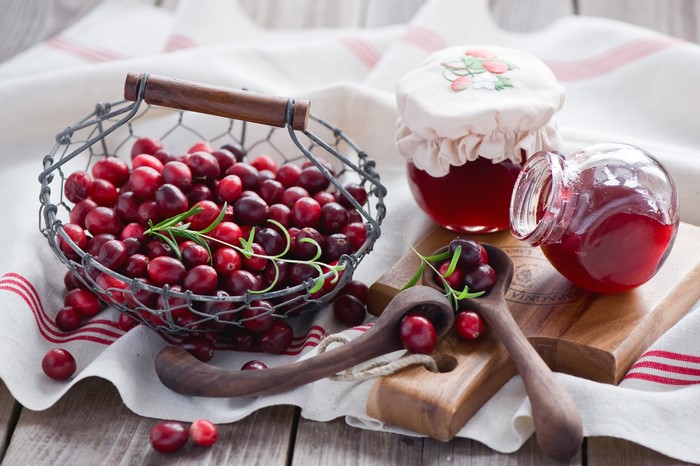 Cranberries and jam in jars and spoons