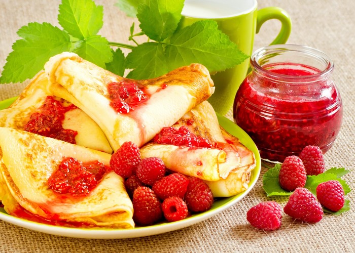 Pancakes with raspberry jam and fresh raspberries