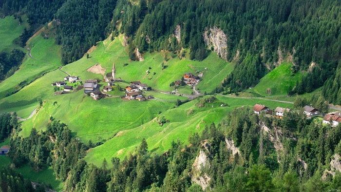 Houses and church in a green mountain valley in Trentino, Italy