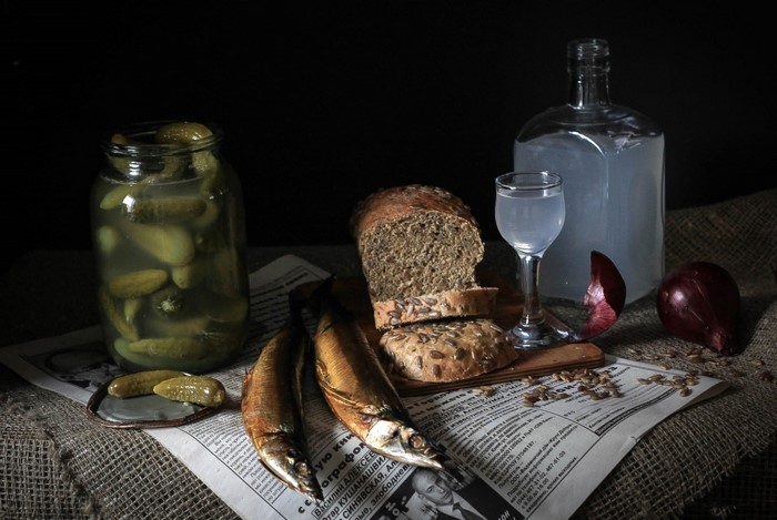 Still life with bread, fish, pickles, vodka, and onion