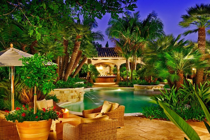 Tropical resort pool area with bar and seating at night