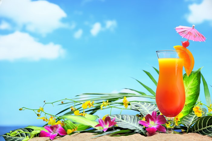 Tropical cocktail on a beach with flowers