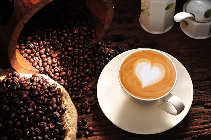 Coffee beans and a cappuccino with heart art