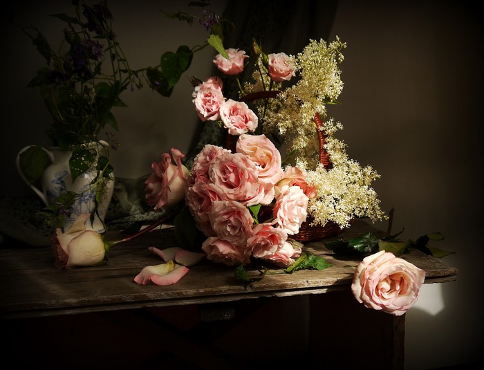 Still-life of pink roses in a vase and basket