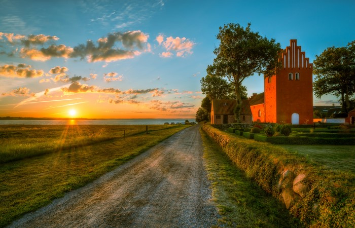 Road to a brick church at sunset