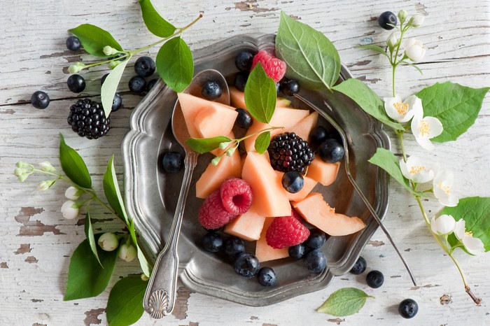 Fruit salad with berries and melon on a plate