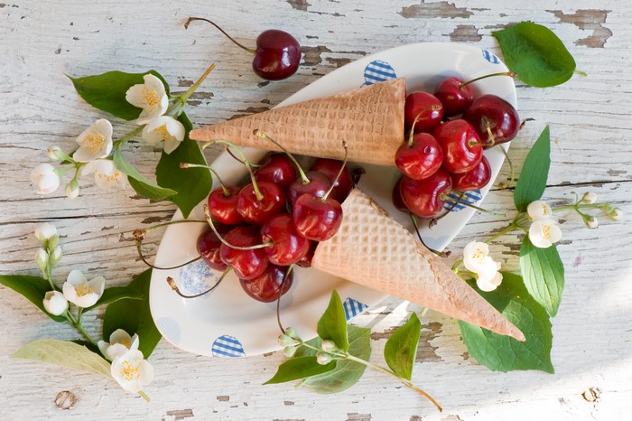 Cherries in ice cream cones on a plate