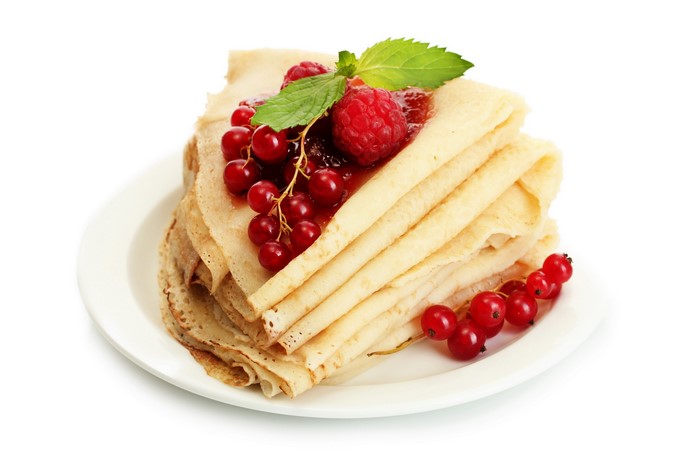 Stack of crepes with raspberries and currants