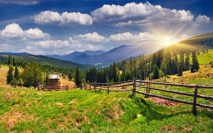 Mountain landscape with sun rays and wooden fence