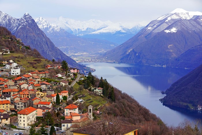 Houses on a hillside overlooking a lake and mountains in Lugano, Switzerland