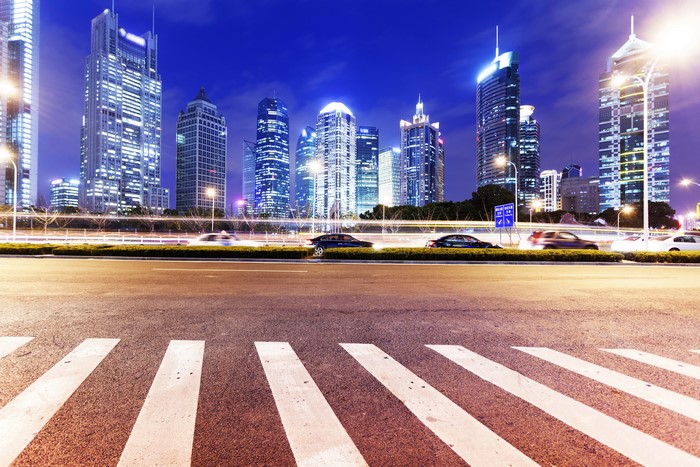 Shanghai skyscrapers at night with traffic on the road
