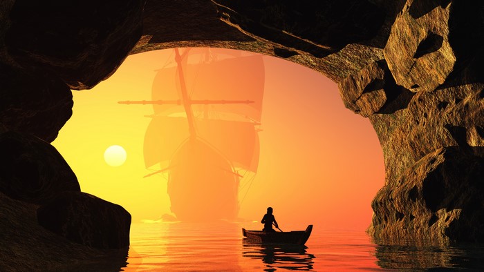 Sailboat and rowboat in a cave at sunset