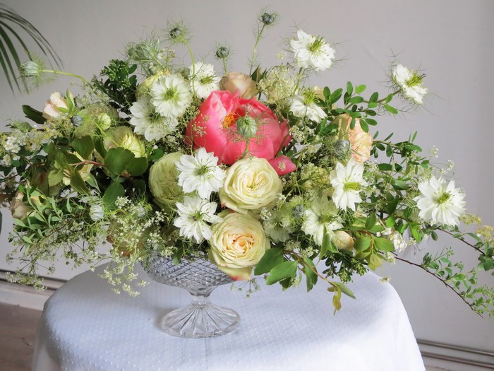 Floral arrangement with peonies, roses, and nigella in a crystal vase