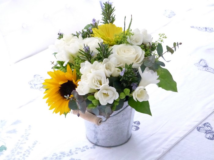 Sunflower and rose bouquet in a metal bucket