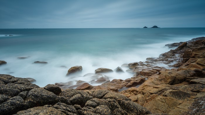 Long exposure of waves crashing on rocky coast in Cornwall, UK
