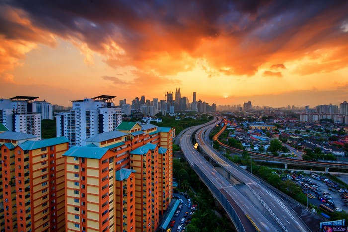 Kuala Lumpur cityscape with highway and apartment buildings at sunset