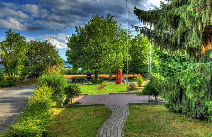 Park with red phone booth in Buseck, Germany