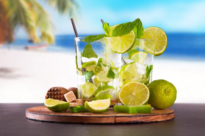 Mojitos with limes and mint on a beach