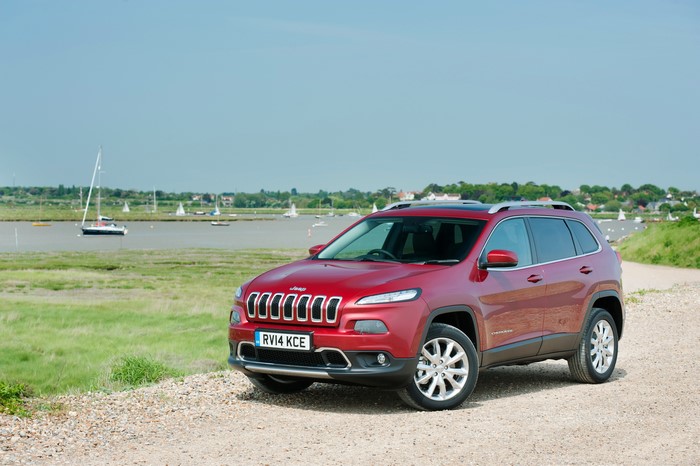 Red 2014 Jeep Cherokee parked by a river