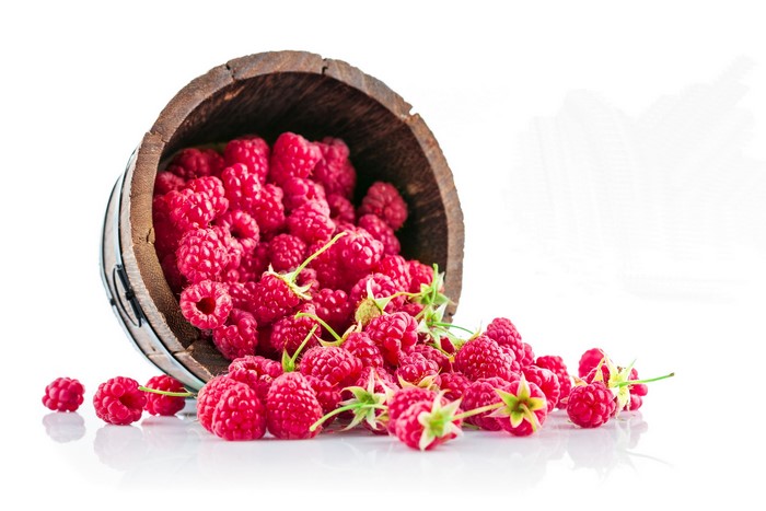Raspberries spilling from a wooden barrel