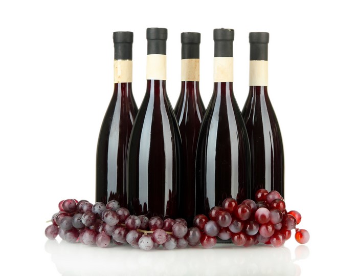 Five bottles of red wine with grapes