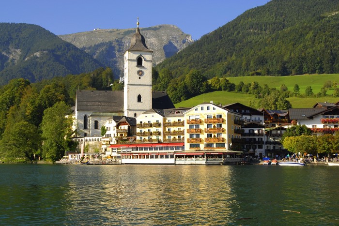 Sankt Wolfgang church and buildings on a lake with mountains